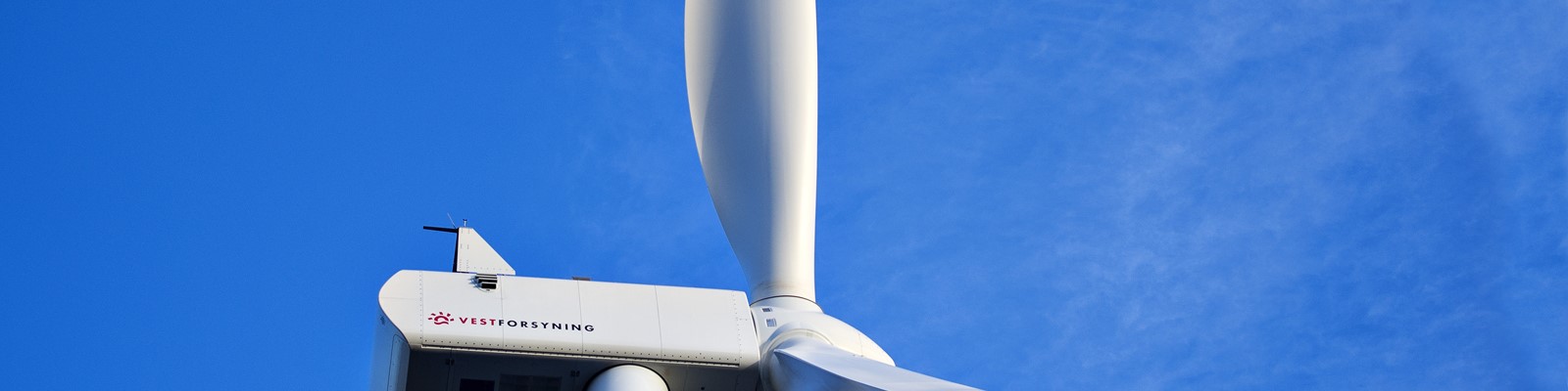 Nærbillede af vindmølle i Gedmose med Vestforsyning logo og blå himmel
